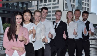 İş ekibi şehir merkezinde baş parmak gösteriyor.