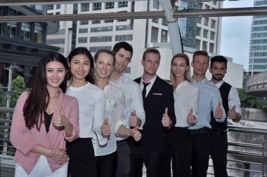 İş ekibi şehir merkezinde baş parmak gösteriyor.