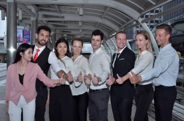 İş ekibi şehir merkezinde baş parmak gösteriyor.