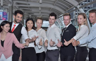 İş ekibi şehir merkezinde baş parmak gösteriyor.