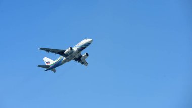 Mavi gökyüzünde uçan uçak.