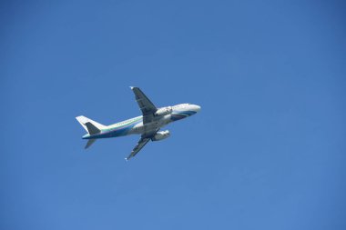 Mavi gökyüzünde uçan uçak.