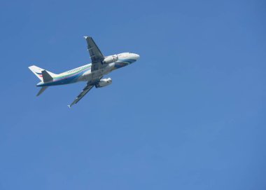 Mavi gökyüzünde uçan uçak.