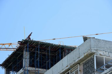 İnşaat işçileri yüksek yerlerde çalışma. Binanın çatı neredeyse bitti.