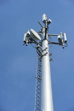 Kablosuz iletişim anteni ile parlak gökyüzü. Telekomünikasyon kule mavi gökyüzü ile antenler ile.