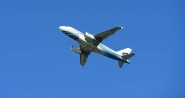 Mavi gökyüzünde uçan uçak