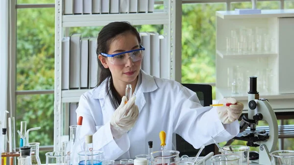 Young women scientists are experimenting with science at the lab.Asian scientist holding a test tube in a laboratory