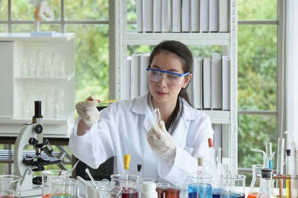 Young women scientists are experimenting with science at the lab.Asian scientist holding a test tube in a laboratory