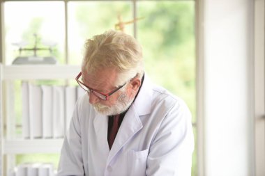 Laboratuarda çalışan yaşlı bir bilim adamı.