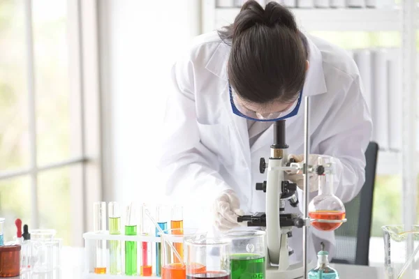 Young women scientists are experimenting with science at the lab.Asian scientist holding a test tube in a laboratory