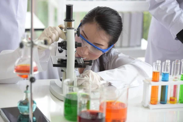 Young women scientists are experimenting with science at the lab.Asian scientist holding a test tube in a laboratory