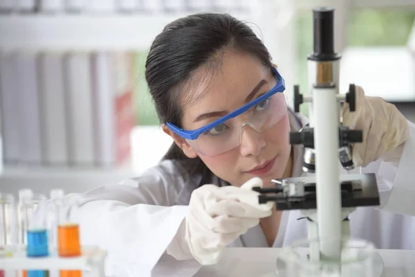 Young women scientists are experimenting with science at the lab.Asian scientist holding a test tube in a laboratory