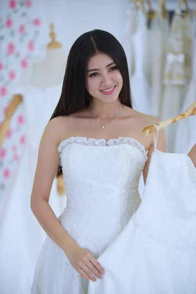 一个穿着美丽礼服的新娘 拿着一束鲜花和绿意盎然的花 婚礼花束 美丽的新娘和新郎在婚纱 — 图库照片