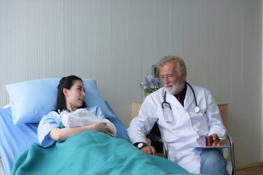 Doktor hastanedeki hastayla konuşuyor.
