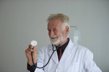 Steteskoplu ve üniformalı yaşlı bir doktor. 