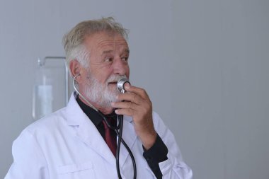 Steteskoplu ve üniformalı yaşlı bir doktor. 