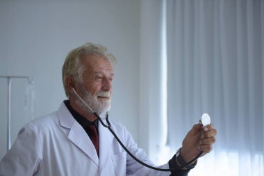 Steteskoplu ve üniformalı yaşlı bir doktor. 