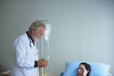Doktor hastane odasında hastayı muayene ediyor.