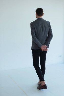 Zarif kostüm giymiş genç beyaz bir adam.