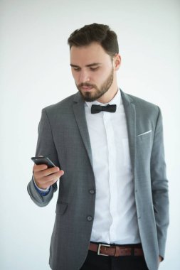 Ayakta ve bir akıllı telefon kullanan adam. Erkekler bir akıllı telefon kullanıyor. Ve yeşil bir ekran olarak telefon göster.