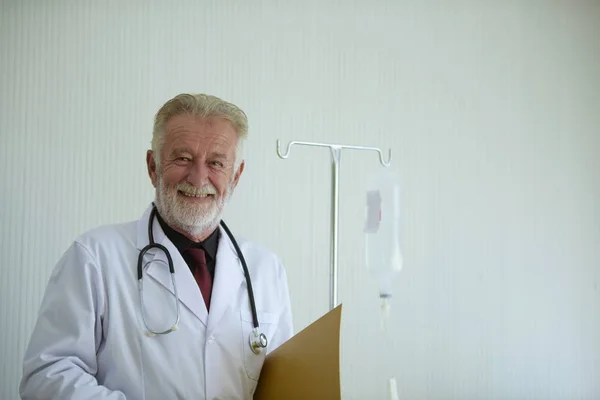 Doctor with clipboard is visiting patient in hospital room