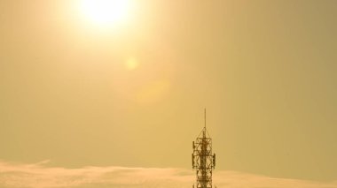 Kablosuz iletişim anteni ile parlak gökyüzü. Telekomünikasyon kule mavi gökyüzü ile antenler ile. Telekomünikasyon turuncu gökyüzü kule. Tv antenleri ve uydu anteni ile iletişim direkleri 