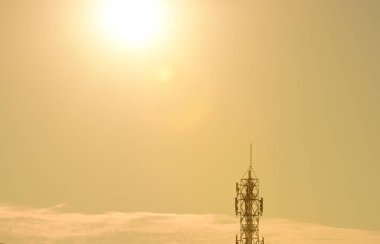 Kablosuz iletişim anteni ile parlak gökyüzü. Telekomünikasyon kule mavi gökyüzü ile antenler ile. Telekomünikasyon turuncu gökyüzü kule. Tv antenleri ve uydu anteni ile iletişim direkleri 