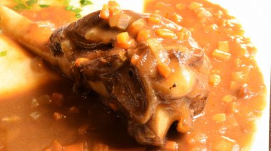 domates soslu kızarmış Kuzu knuckle.lamb knuckls kızarmış. Kavrulmuş patates ve havuç ile cömert kopya alanı rustik bir ortamda tarz ile kuzu incik kızartma.