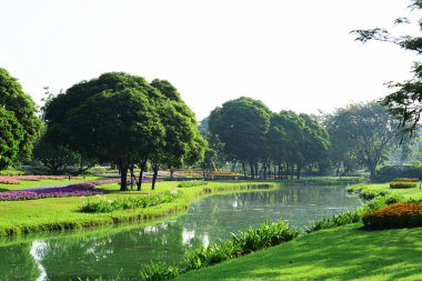 Bahçıvan uzun 9 Park'ta parkta Çiçekleri suluyordum. Bangkok Thailandthe güzel çiçek bahçesinde Bangkok en büyük şehir parkı