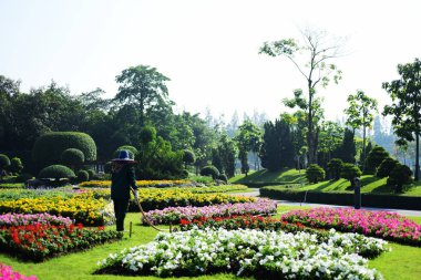 Bahçıvan uzun 9 Park'ta parkta Çiçekleri suluyordum. Bangkok Thailand.The güzel çiçek bahçesinde Bangkok en büyük şehir parkı