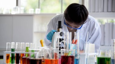 Genç bilim adamları laboratuarda test tüpü tutan Asya bilim adamı, bilim ile çalışıyoruz. Bilim adamları bilim laboratuarları içinde çalışıyoruz. Laboratuvar ve laboratuvar Equipment.microbiological analizi, tıp.
