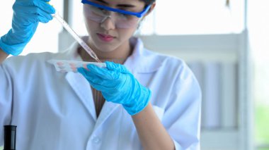 Genç bilim adamları laboratuarda test tüpü tutan Asya bilim adamı, bilim ile çalışıyoruz. Bilim adamları bilim laboratuvarlarında çalışıyoruz. 