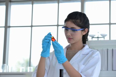 Genç bilim adamları laboratuarda test tüpü tutan Asya bilim adamı, bilim ile çalışıyoruz. Bilim adamları bilim laboratuvarlarında çalışıyoruz. 