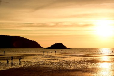 Gün batımında güzel sahil manzarasında birçok insan gün batımından önce oynamak için sahile gelirler..
