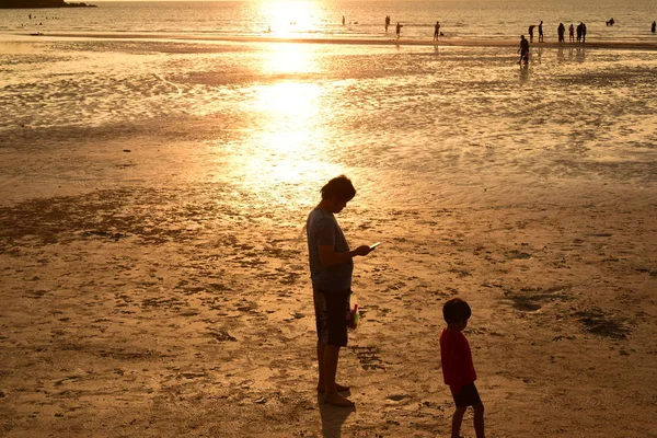 美しいビーチビューでの夕日夕暮れ前に海で遊ぶ人がたくさんいます ビーチでの夕日のシルエット — ストック写真