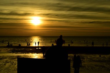 Gün batımında güzel sahil manzarasında birçok insan gün batımından önce oynamak için sahile gelirler..