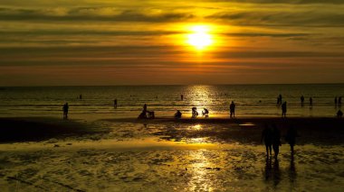 Gün batımında güzel sahil manzarasında birçok insan gün batımından önce oynamak için sahile gelirler..