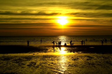 Gün batımında güzel sahil manzarasında birçok insan gün batımından önce oynamak için sahile gelirler..
