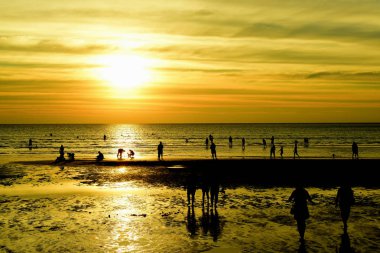 Gün batımında güzel sahil manzarasında birçok insan gün batımından önce oynamak için sahile gelirler..