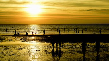 Gün batımında güzel sahil manzarasında birçok insan gün batımından önce oynamak için sahile gelirler..