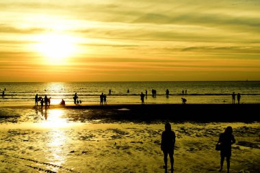 Gün batımında güzel sahil manzarasında birçok insan gün batımından önce oynamak için sahile gelirler..