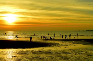 Gün batımında güzel sahil manzarasında birçok insan gün batımından önce oynamak için sahile gelirler..