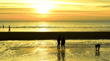 Gün batımında güzel sahil manzarasında birçok insan gün batımından önce oynamak için sahile gelirler..