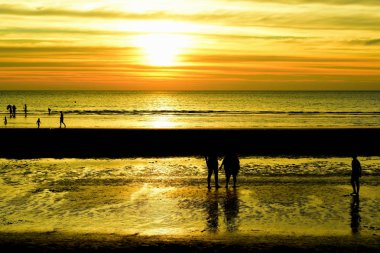 Gün batımında güzel sahil manzarasında birçok insan gün batımından önce oynamak için sahile gelirler..