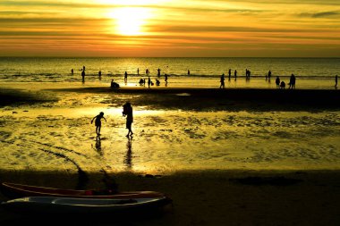 Gün batımında güzel sahil manzarasında birçok insan gün batımından önce oynamak için sahile gelirler..