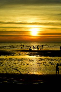 Gün batımında güzel sahil manzarasında birçok insan gün batımından önce oynamak için sahile gelirler..