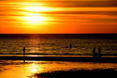 Gün batımında güzel sahil manzarasında birçok insan gün batımından önce oynamak için sahile gelirler..
