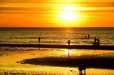Gün batımında güzel sahil manzarasında birçok insan gün batımından önce oynamak için sahile gelirler..