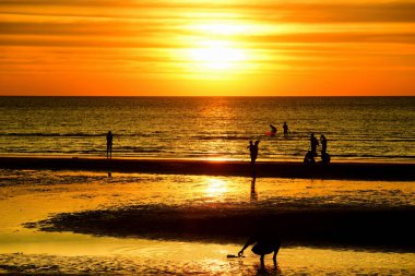 Gün batımında güzel sahil manzarasında birçok insan gün batımından önce oynamak için sahile gelirler..