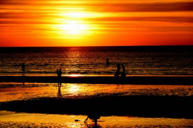 Gün batımında güzel sahil manzarasında birçok insan gün batımından önce oynamak için sahile gelirler..